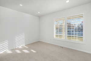 Carpeted spare room featuring plenty of natural light