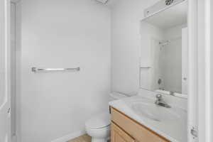 Bathroom featuring vanity, a shower, tile patterned floors, and toilet