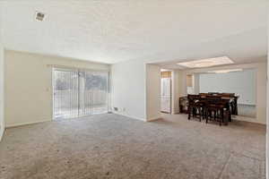 Carpeted living room with a textured ceiling