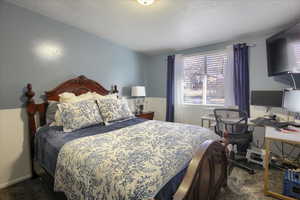 Carpeted bedroom with a textured ceiling