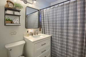 Bathroom with walk in shower, vanity, and toilet