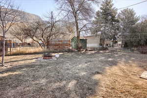 View of yard featuring a storage unit and an outdoor fire pit