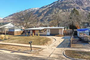 Ranch-style house with brick siding, fence, and a mountain view