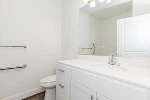 Bathroom with wood-type flooring, toilet, and vanity