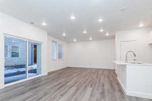 Unfurnished living room featuring sink and light hardwood / wood-style flooring