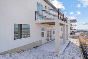 Snow covered property with a balcony