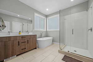 Bathroom featuring vanity and independent shower and bath