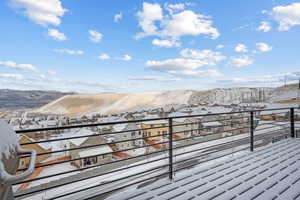 Snow covered deck featuring a mountain view