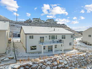 Snow covered house featuring a balcony