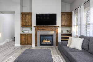 Living room featuring a tiled fireplace and light hardwood / wood-style floors