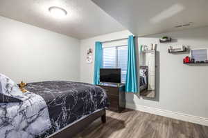 Bedroom with hardwood / wood-style flooring and a textured ceiling