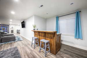 Bar featuring hardwood / wood-style flooring