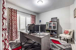 Office area featuring light hardwood / wood-style flooring and a textured ceiling