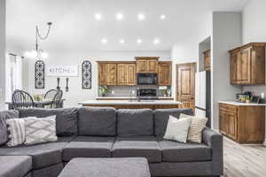 Living room with an inviting chandelier and light hardwood / wood-style floors