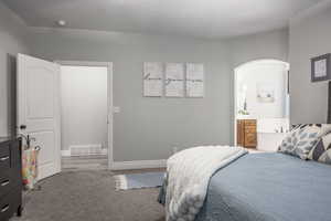 Carpeted bedroom featuring connected bathroom