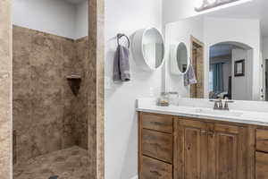 Bathroom featuring vanity and tiled shower