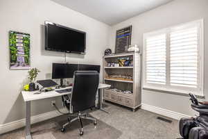 Office area featuring carpet floors and a textured ceiling