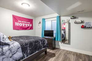 Bedroom featuring hardwood / wood-style floors and a textured ceiling