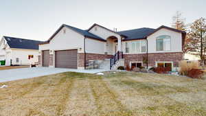 View of front of home with a garage and a front lawn