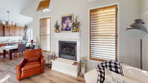 Living room with lofted ceiling and light hardwood / wood-style floors