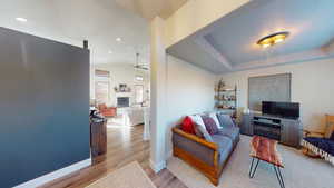 Living room featuring vaulted ceiling, light hardwood / wood-style floors, and ceiling fan