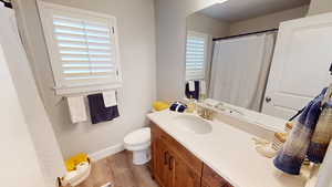 Bathroom with vanity, wood-type flooring, and toilet