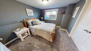 Bedroom featuring dark colored carpet