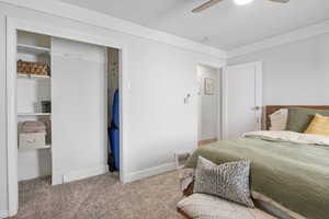 Carpeted bedroom with a closet and ceiling fan