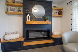 Living room featuring carpet and a fireplace