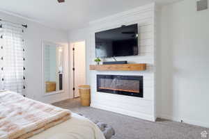 Carpeted bedroom featuring a large fireplace