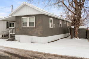 View of snow covered exterior featuring cooling unit