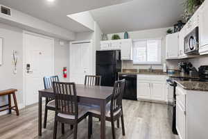 Dining area featuring sink, light hardwood / wood-style floors, and a textured ceiling