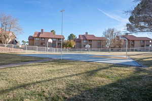 Exterior space with basketball court and a lawn