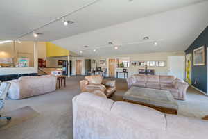 Living room featuring lofted ceiling and light carpet