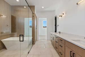 Bathroom featuring vanity, tile patterned flooring, and shower with separate bathtub