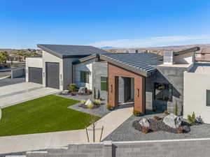 Contemporary house featuring a garage, a mountain view, and a front lawn