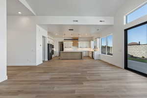 Kitchen with light wood-type flooring, hanging light fixtures, a wealth of natural light, and a kitchen island