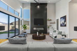 Living room featuring a large fireplace, hardwood / wood-style floors, and a high ceiling