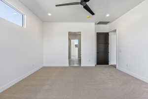 Unfurnished bedroom with ceiling fan and light colored carpet