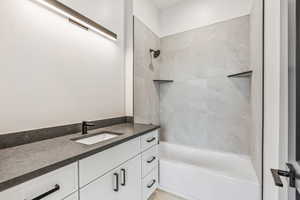 Bathroom with vanity and tiled shower / bath