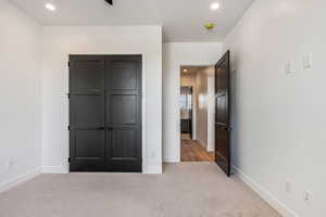 Unfurnished bedroom featuring light carpet