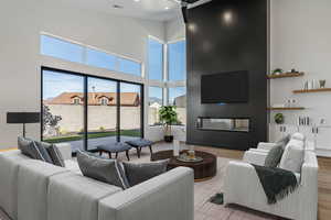 Living room with a high ceiling and light hardwood / wood-style floors