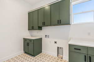 Washroom with hookup for a washing machine, cabinets, and hookup for an electric dryer