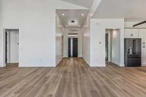 Interior space with light hardwood / wood-style flooring and a high ceiling