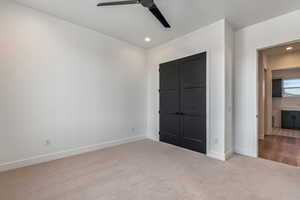 Unfurnished bedroom with light carpet and ceiling fan