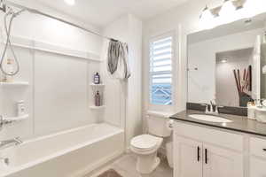 Full bathroom featuring vanity, tile patterned floors, shower / bath combination with curtain, and toilet