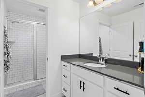 Bathroom with vanity and a shower with door