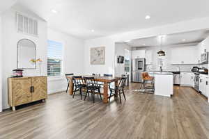 Dining space with sink, plenty of natural light, and light wood-type flooring