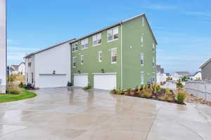 View of side of home with a garage and central AC unit