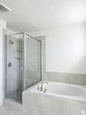 Bathroom with shower with separate bathtub and a textured ceiling